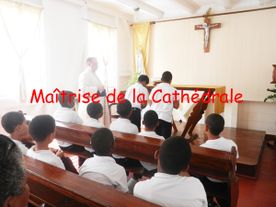 Des enfants et un prêtre dans une église en train de prier