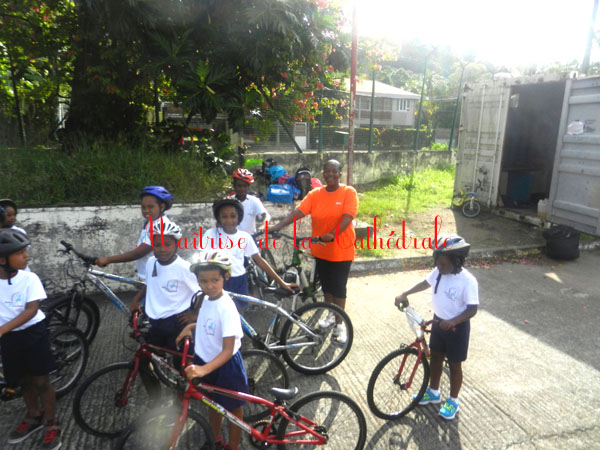 Six enfants et un adulte en t-shirt orange sont sur des vélos