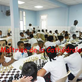 De nombreux enfants jouent aux échecs dans une salle bleue et blanche