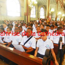 Des enfants assis dans une église portant l'uniforme de l'école de la Maîtrise Cathédrale