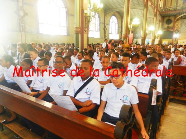 Des enfants assis dans une église portant l'uniforme de l'école de la Maîtrise Cathédrale